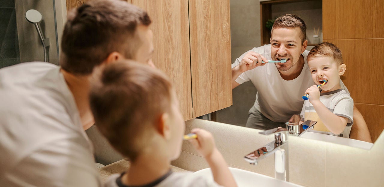 Papa avec son fils se brossant les dents