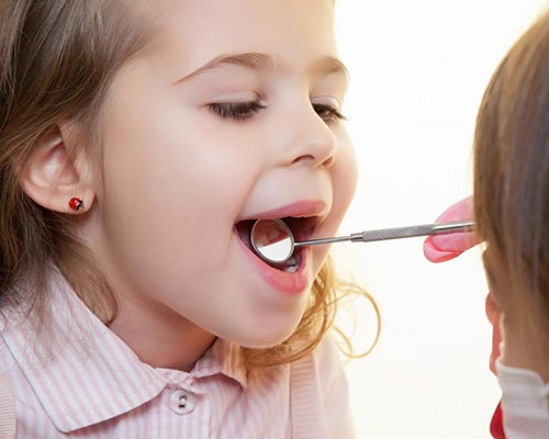 enfant ouvrant la bouche au dentiste
